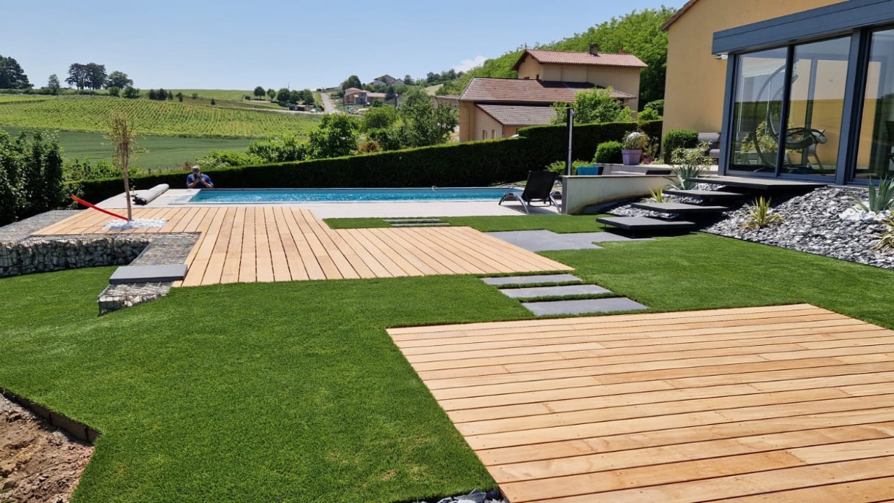 Création d'un jardin avec gazon et terrasse bois autour d'une piscine pour une maison moderne dans le Maconnais