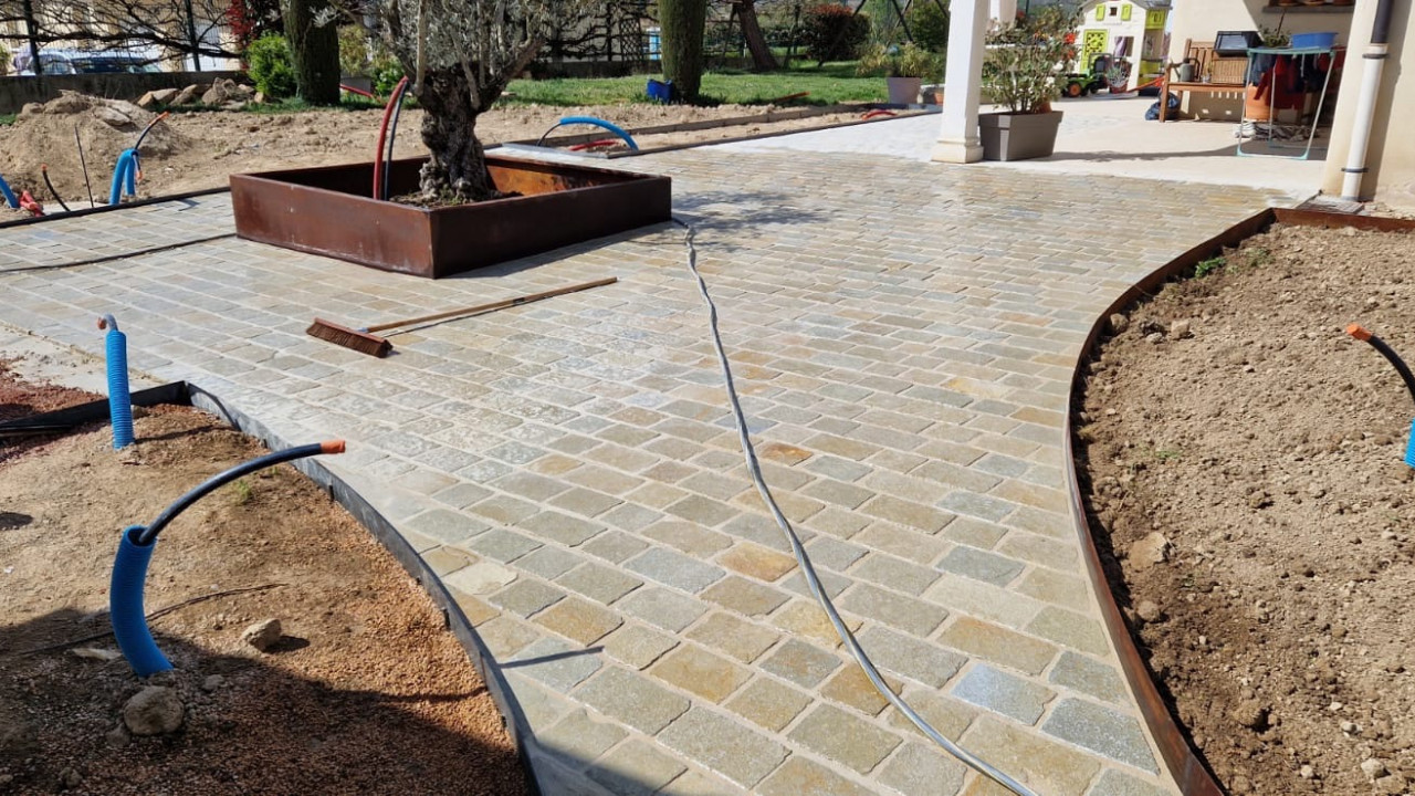 Réalisation d'une cours en pavés calcaire avec bordure et jardinière acier corten chez un particulier à la Chapelle de Guinchay