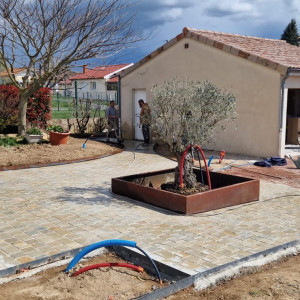 Réalisation d'une cours en pavés calcaire avec bordure et jardinière acier corten chez un particulier à la Chapelle de Guinchay