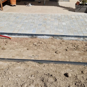 Réalisation d'une cours en pavés calcaire avec bordure et jardinière acier corten chez un particulier à la Chapelle de Guinchay