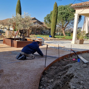 Réalisation d'une cours en pavés calcaire avec bordure et jardinière acier corten chez un particulier à la Chapelle de Guinchay